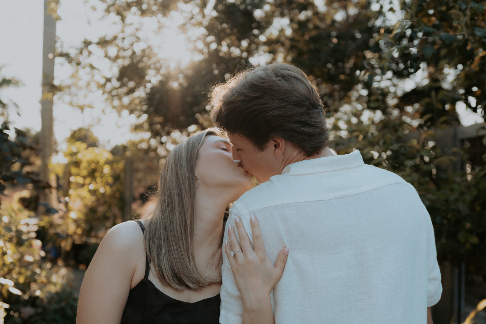 Nathan and Natalie sharing a kiss in the warm garden light.